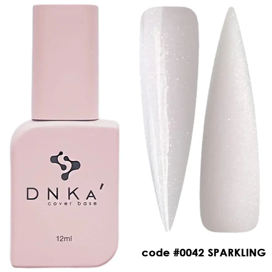A nail polish bottle labeled DNKa' Cover Base, with a volume of 12 ml, in a sparkling white color. A sample nail is shown with the product applied, displaying its shiny finish. 0042 Sparkling