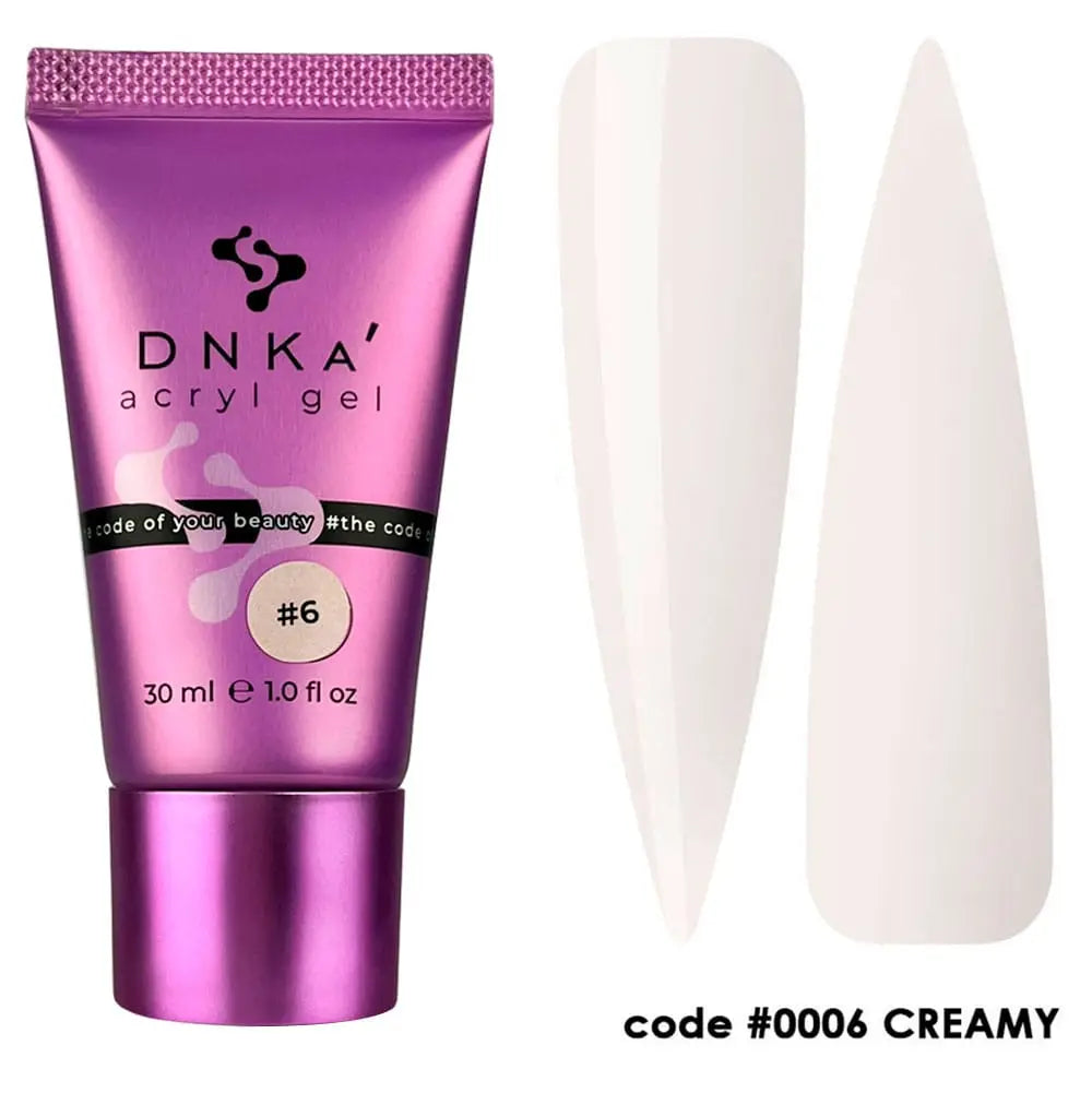 A tube of DNKa' Acryl Gel #0006 Creamy with a purple cap, alongside a pair of white nail extensions. The code #0006 Creamy is visible on the tube.