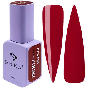 A red-colored gel polish bottle with the cap removed, showing a red-colored gel polish inside. Next to the bottle, there is a red-colored nail polish swatch. DNKA 0082 color