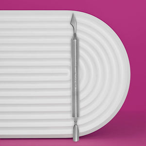 A stainless steel cuticle pusher with a hollow handle, featuring a rounded pusher and cleaner on a white ribbed surface with a pink background.