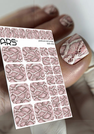 Sheet of snake patterned nail wraps with a hand wearing a nail with the design.