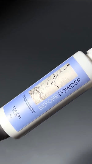 A white cylindrical cosmetic bottle labeled 'TOUCH BEFORE POWDER' with a light blue label and a marble-style graphic, shown against a dark gray gradient background.