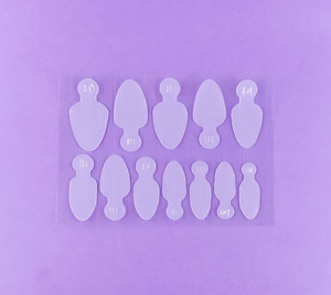 A set of 36 clear silicone nail molds arranged in four rows on a purple background.