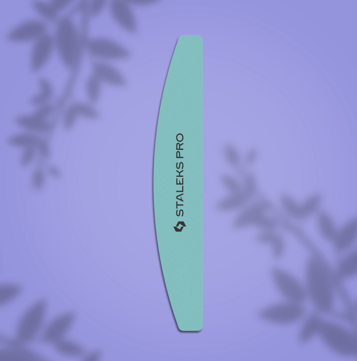 A nail file with a crescent shape and two working sides, marked with the brand name 'Staleks Pro', displayed on a purple background with plant shadows.
