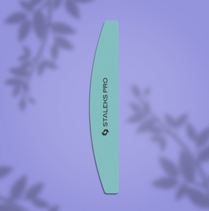 A nail file with a crescent shape and two working sides, marked with the brand name 'Staleks Pro', displayed on a purple background with plant shadows.