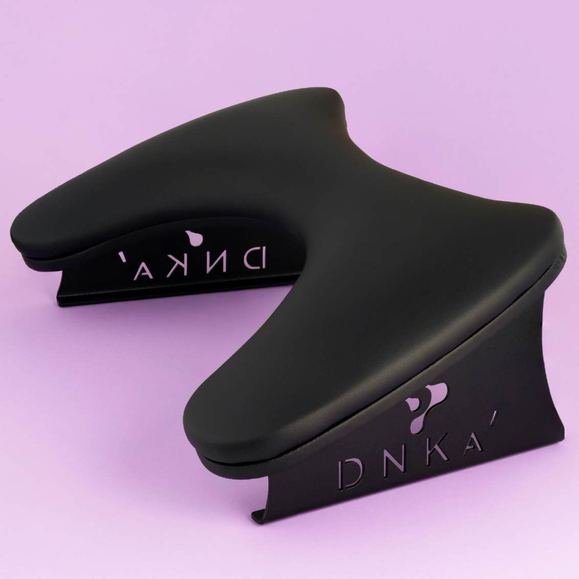 Black ergonomic wrist rest on a light purple background. Armrest in black