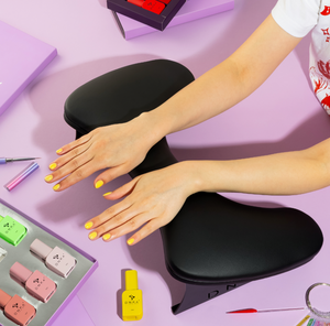 Black ergonomic wrist rest on a light purple background. Armrest in black