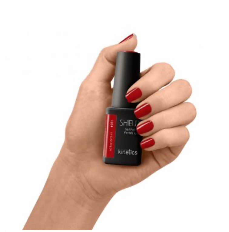 Dark red gel polish color of Kinetics brand on white background in the hand