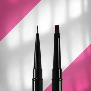 Two black makeup brushes with brown bristles on a pink and white background