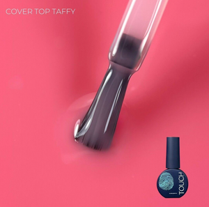 Nail polish brush with dark blue nail polish on a pink background, featuring the brand 'Touch'.