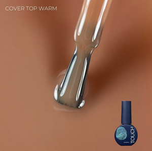 Nail polish droplet with a blue nail polish bottle labeled 'TOUCH' on a brown background.
