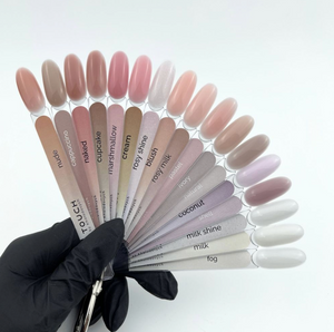 Nail color swatches held by a gloved hand on a white background