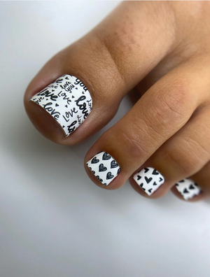 Nail art with black text and heart patterns on a white background
