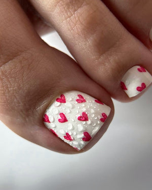 Nail art with red hearts on a white background