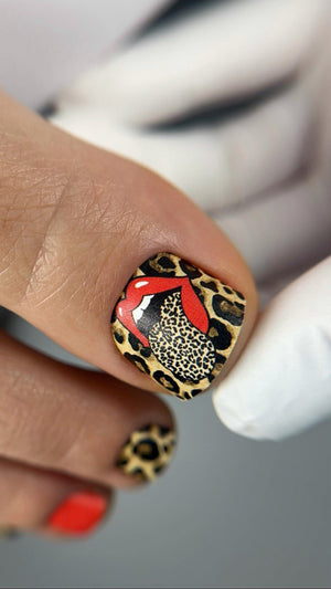 Nail with leopard print and red design on a blurred background