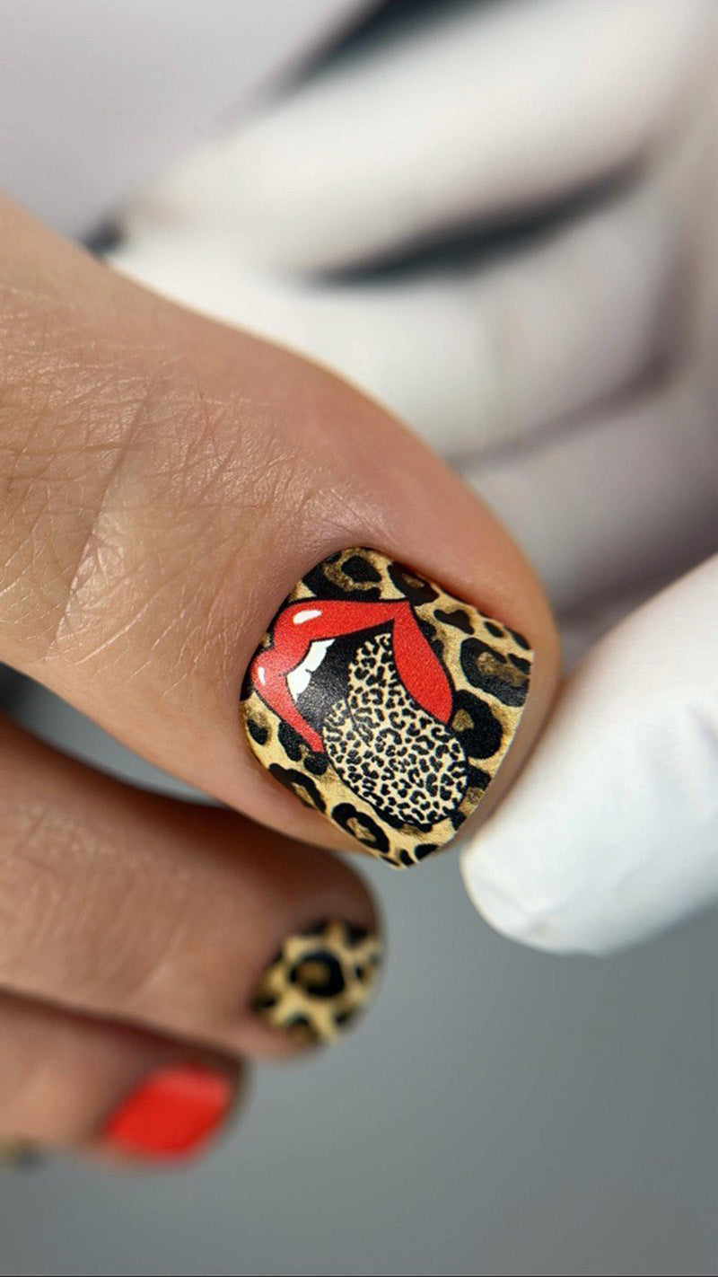 Nail with leopard print and red design on a blurred background
