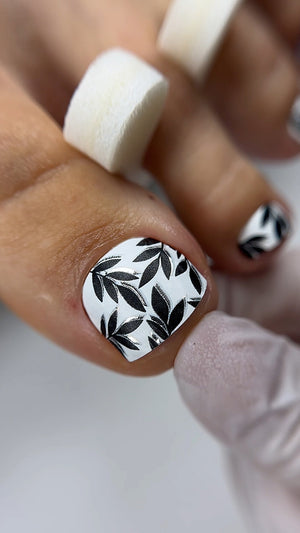 Nail with black leaf pattern on a white background