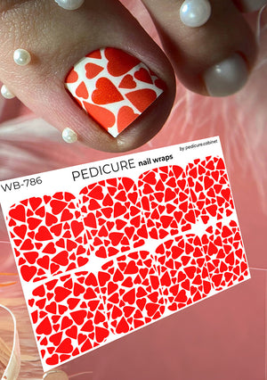 Nail with red heart pattern and matching nail wrap packaging.