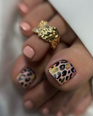 Nail art with leopard print design and gold accents on a neutral background