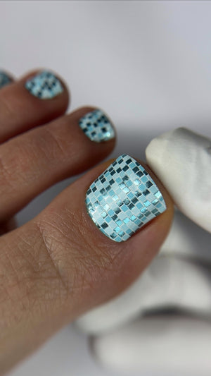 Nails with a checkered pattern in light blue and white on a neutral background