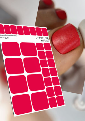 Sheet of red pedicure nail wraps with a blurred background of a hand with red nails.