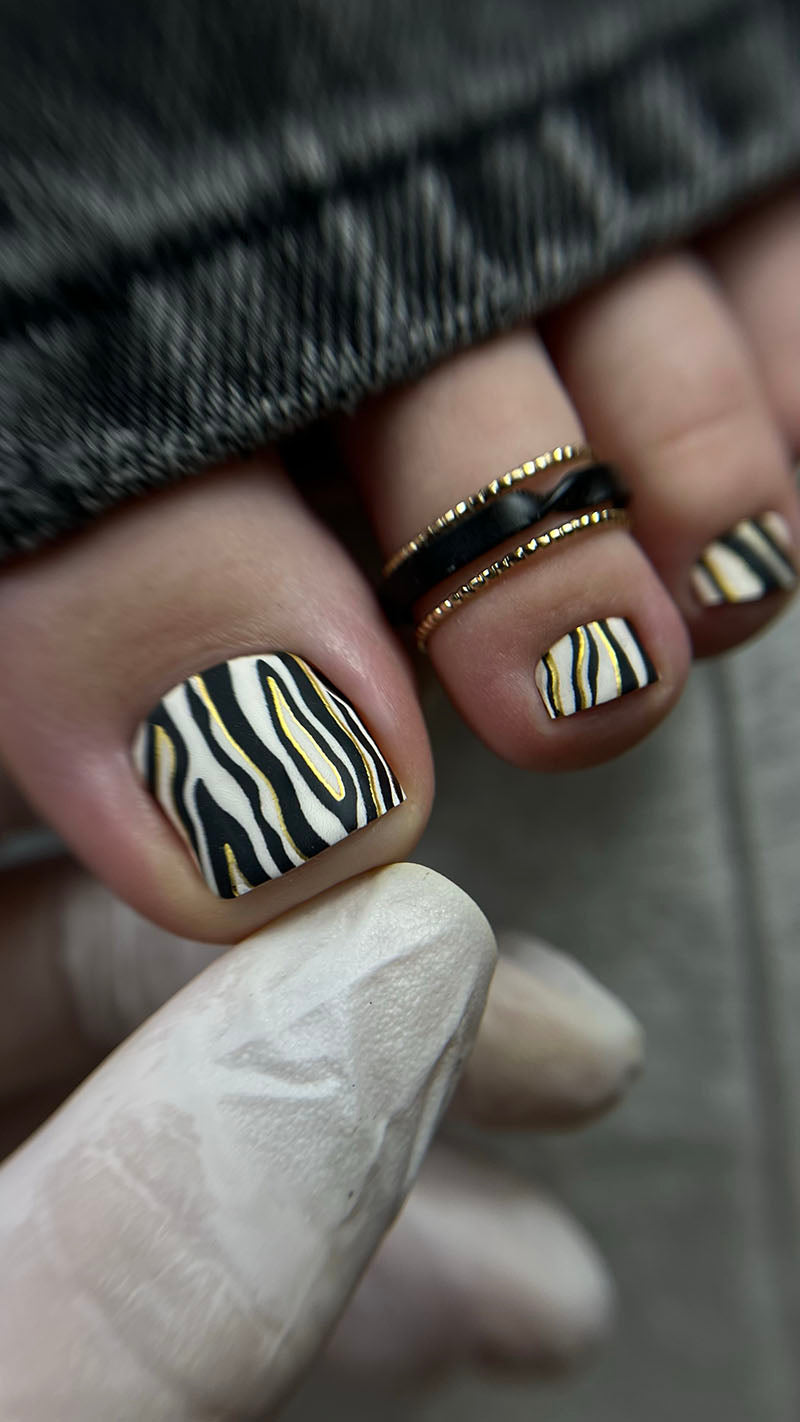 Nails with zebra pattern design on a neutral background