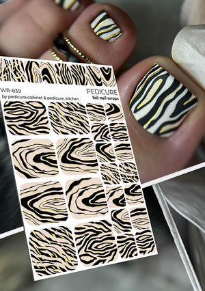 Zebra patterned nail wraps with a person's hand showing nails with similar design.