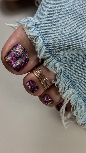 Close-up of a hand with colorful nail design wearing denim jeans.
