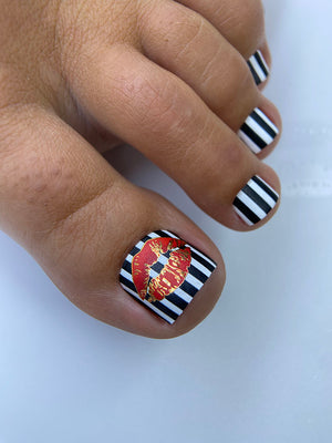 Nail art with black and white stripes and a red and gold design on a white background