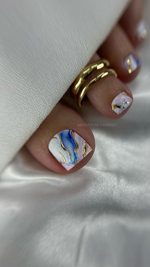 Close-up of a hand with marbleized nail art on a white background