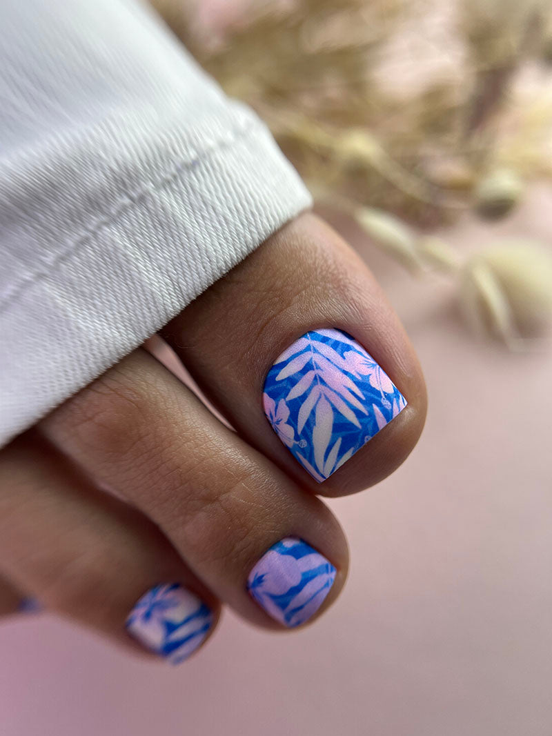 Nail with blue and white abstract design on a blurred background