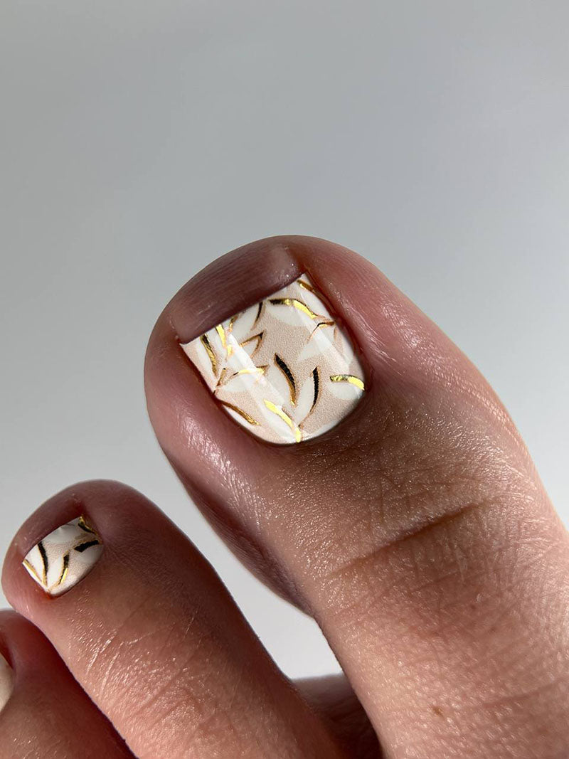 Close-up of a hand with marbleized nail design on a neutral background