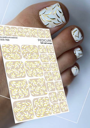 Foil nail wraps with gold patterns on a white background