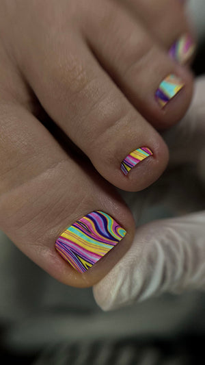 Close-up of toes with colorful nail art on a blurred background