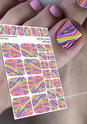 Colorful nail wrap sheet with swirled pattern and a hand with pink nail polish holding it.