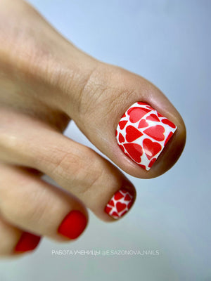 Nail art with red heart patterns on a light background