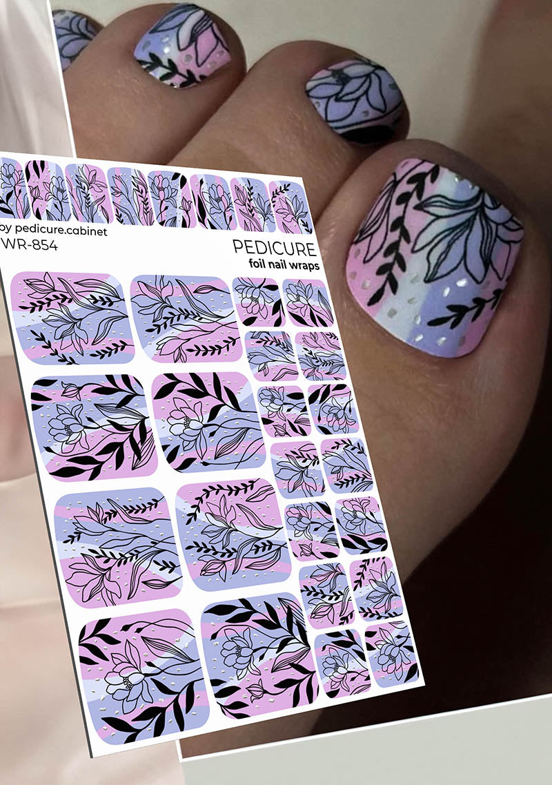 Nail art foil wraps with floral designs held by a hand with painted nails.