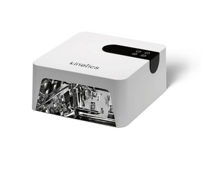 A Kinetics UV light curing device in white and black, shown at an angle with its internal LED light source visible through a transparent front panel, on a white background.