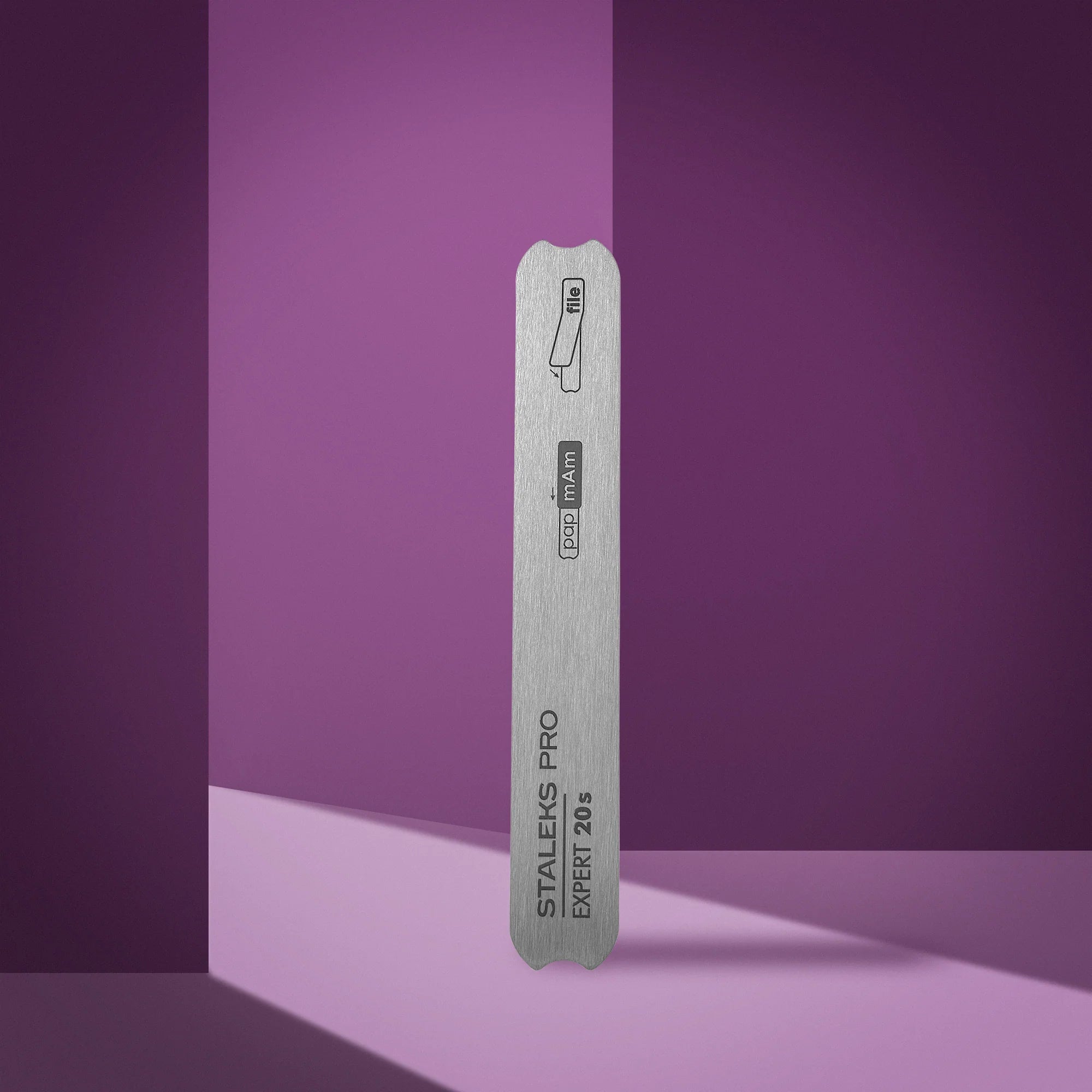 A straight metal nail file base with notches, branded as 'Staleks Pro', against a purple background.