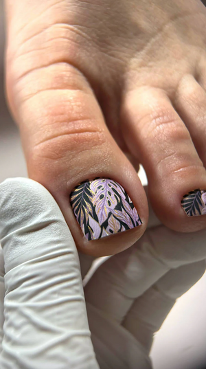 Close-up of a hand with decorative nail art on a neutral background