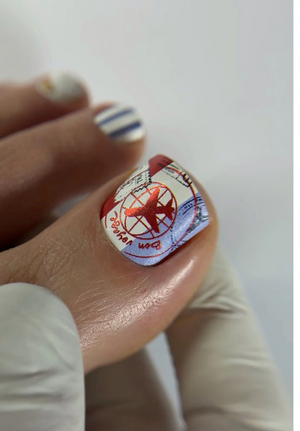 Finger with a nail design featuring a red airplane on a white background