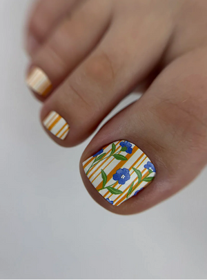 Nail with floral and striped design on a neutral background