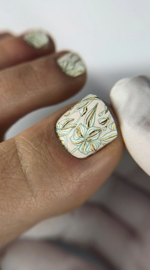 Close-up of a hand with a decorative nail design on a white background