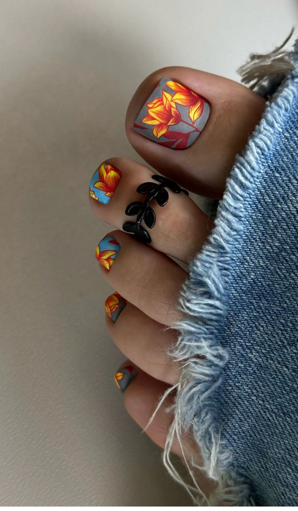 Close-up of toes with colorful nail art on a neutral background