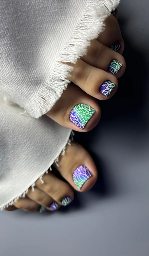 Close-up of toes with colorful nail art on a neutral background