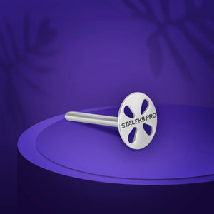 A small, round, stainless steel pedicure disc with the brand 'STALEKS PRO' inscribed on it, displayed against a purple background.