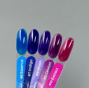 Set of nail polish samples with color names and codes on a gray background