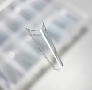 Clear glass vase on a reflective surface with geometric patterns