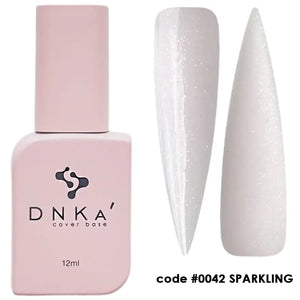 A nail polish bottle labeled DNKa' Cover Base, with a volume of 12 ml, in a sparkling white color. A sample nail is shown with the product applied, displaying its shiny finish. 0042 Sparkling