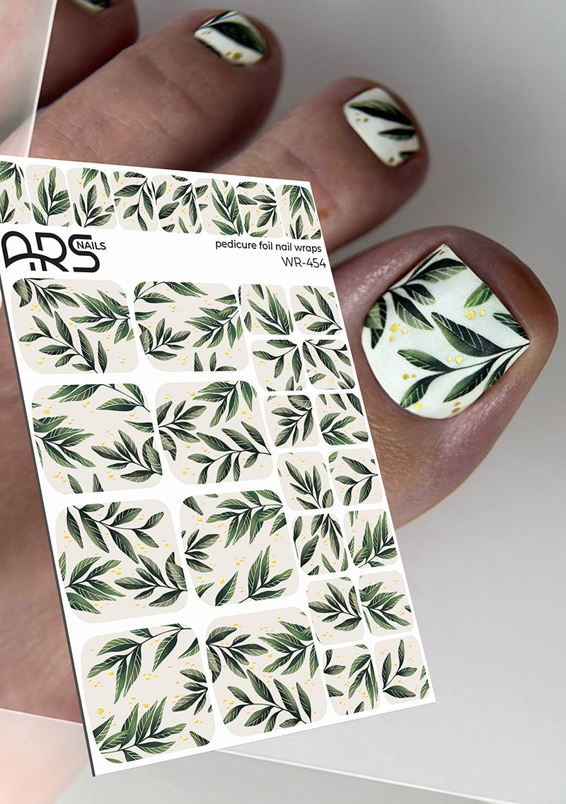 Nail art stickers with leaf design held by a hand with matching nail art.